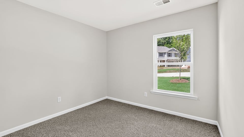 Bedroom with carpet and windows.