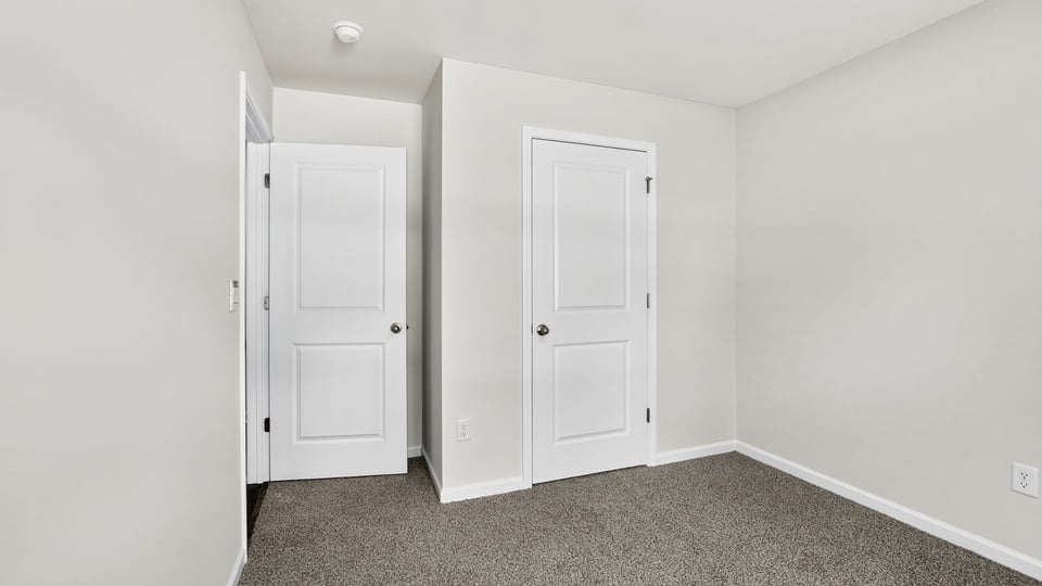 Bedroom with carpet and windows.
