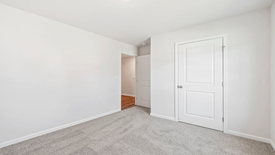 Bedroom with carpet and window.