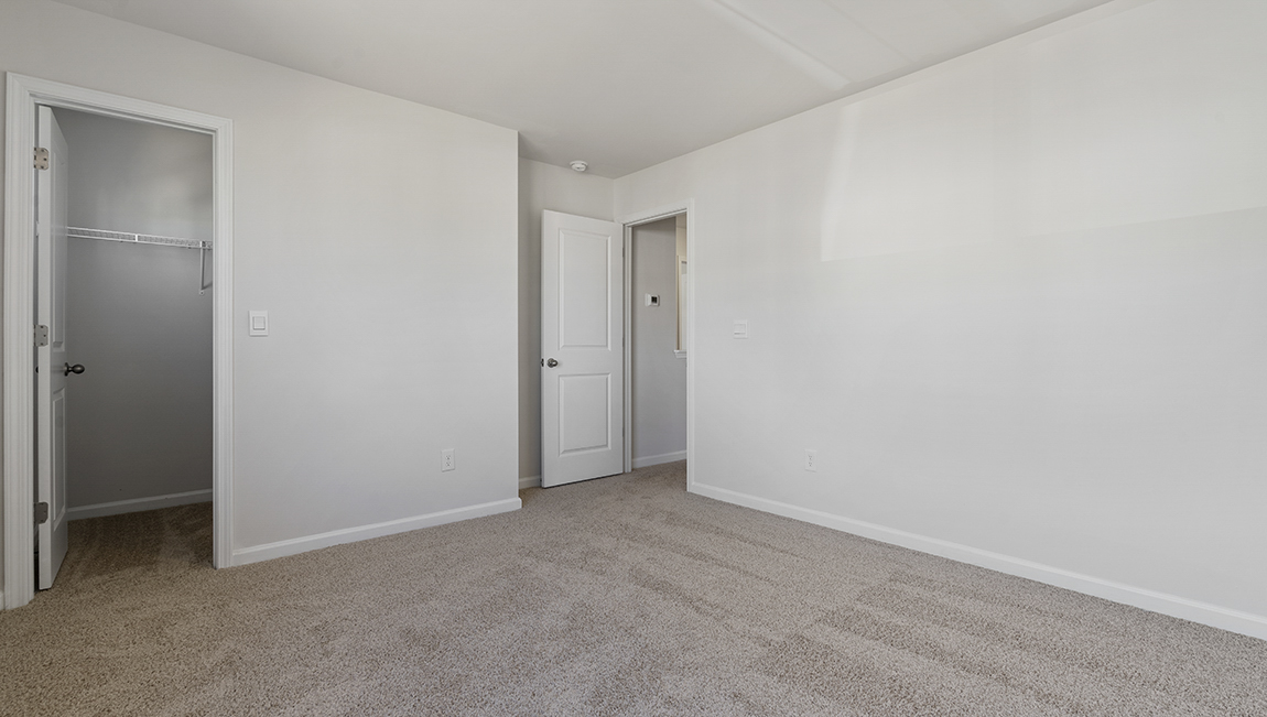 Carpeted bedroom with small window