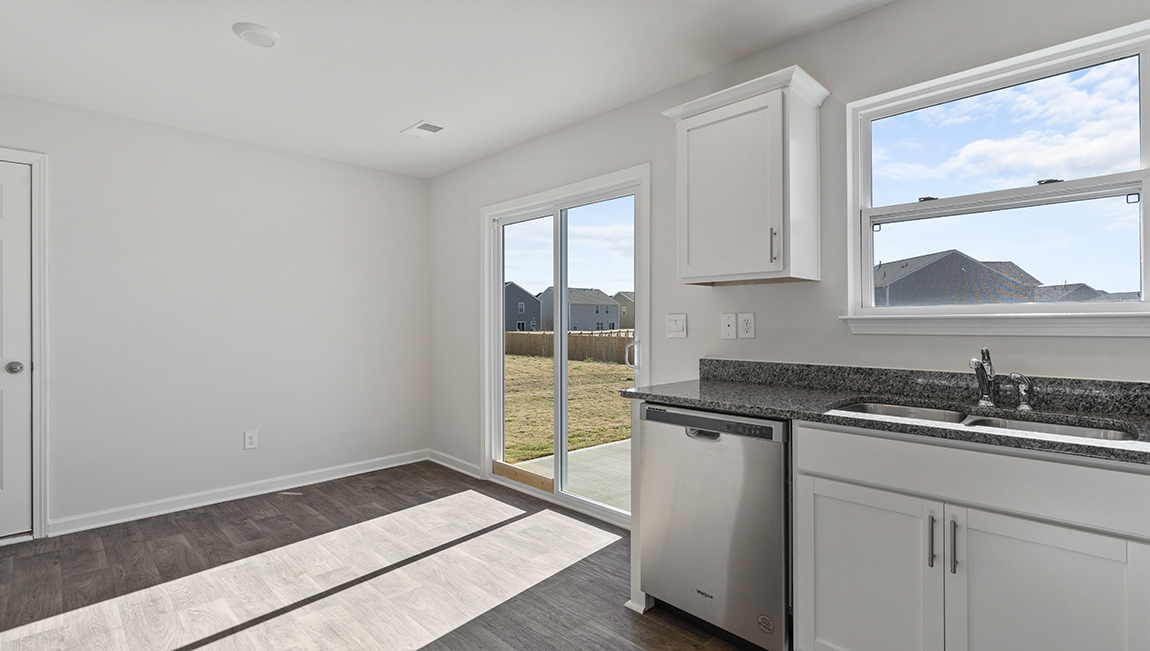 Open kitchen with white cabinets, and stainless steel appliances