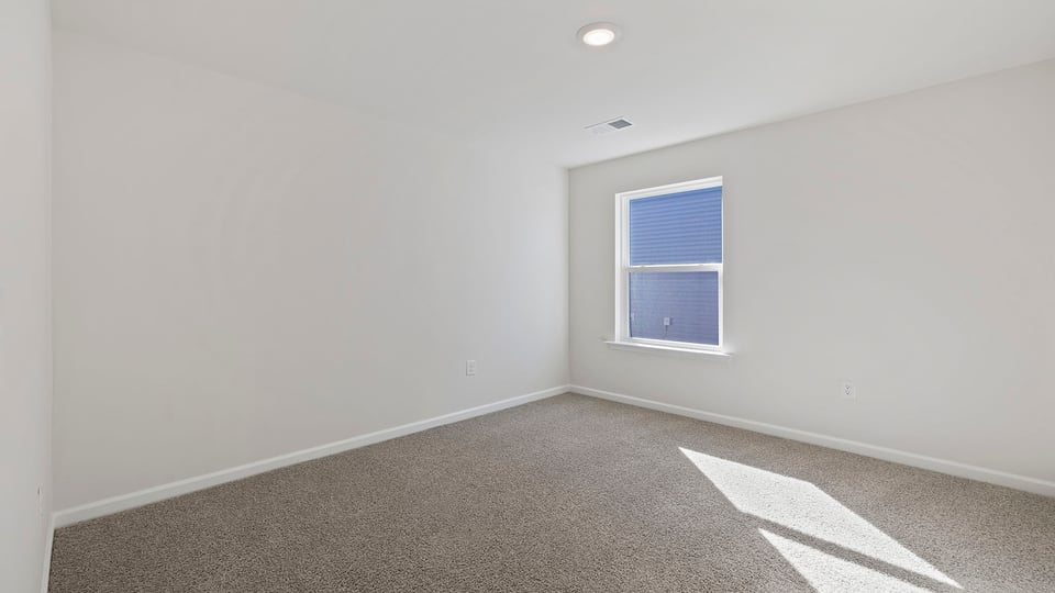 Bedroom with carpet and window.
