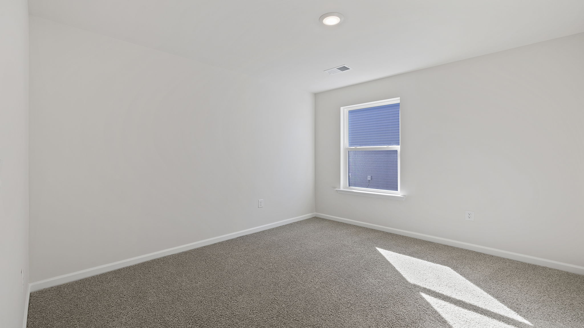 Bedroom with carpet and window.
