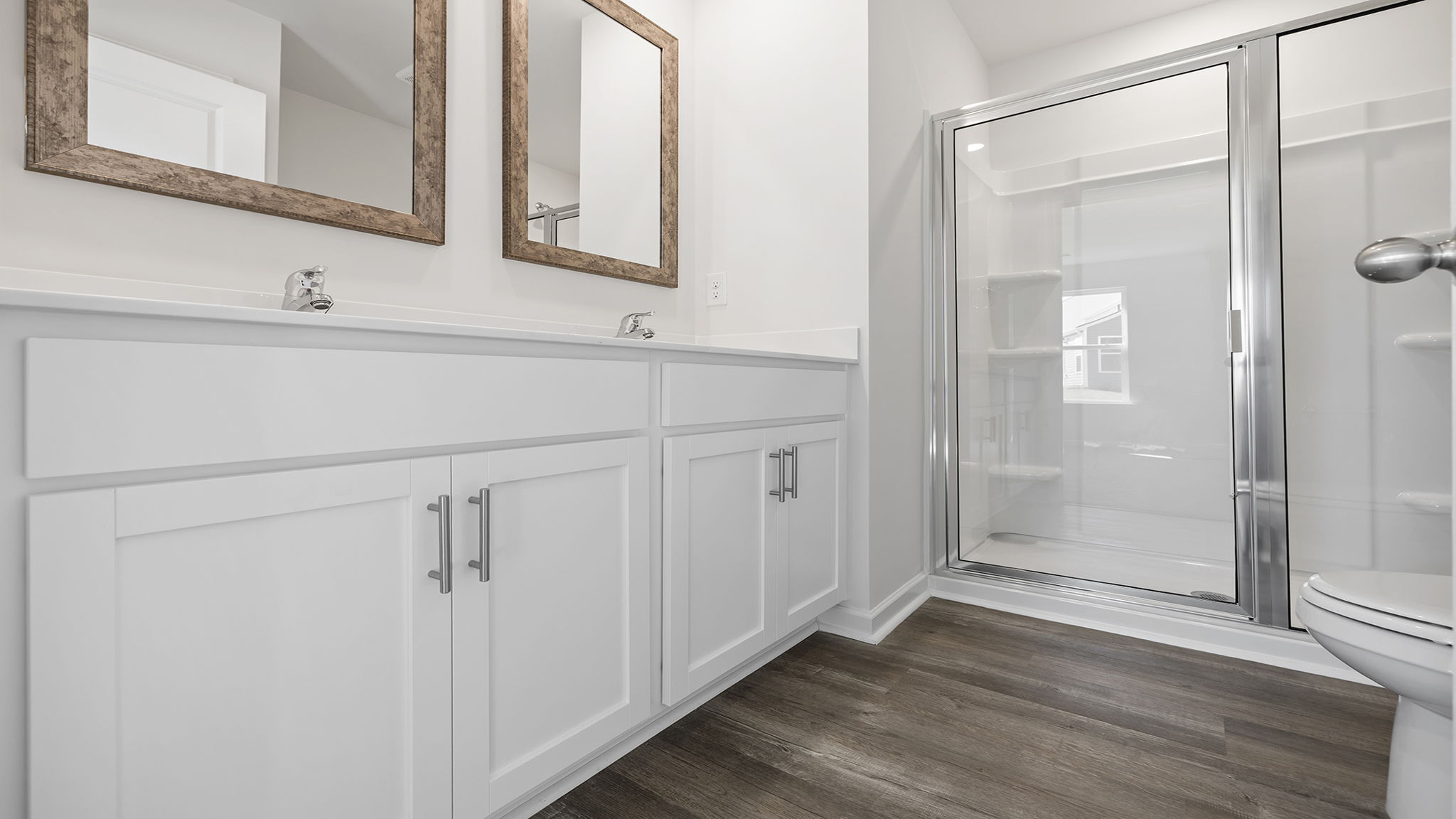Bathroom with double vanity sink and shower.