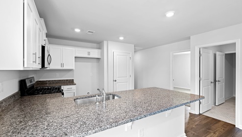 Kitchen and island with granite counter tops.