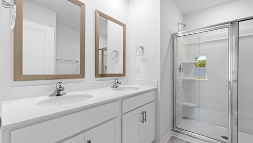 Bathroom with double vanity sink and shower.