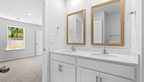 Bathroom with double vanity sink and shower.