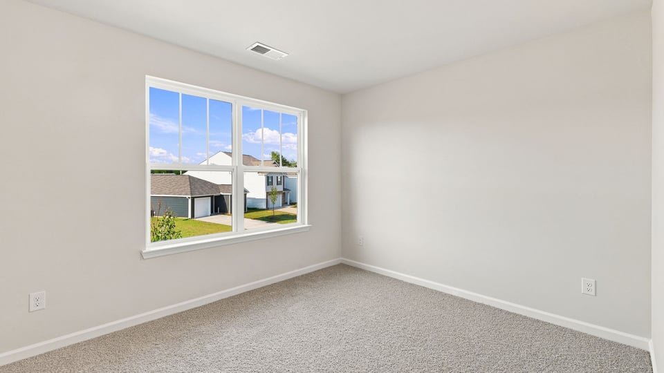 Bedroom with carpet and window.