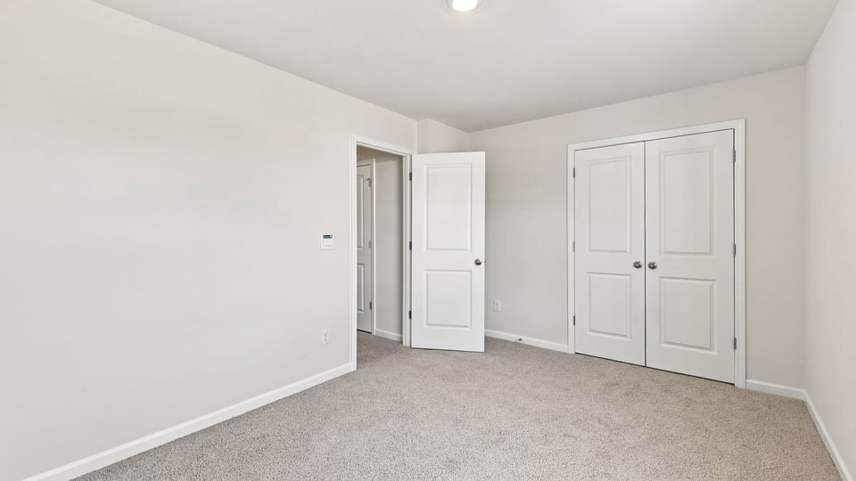 Bedroom with carpet and window.