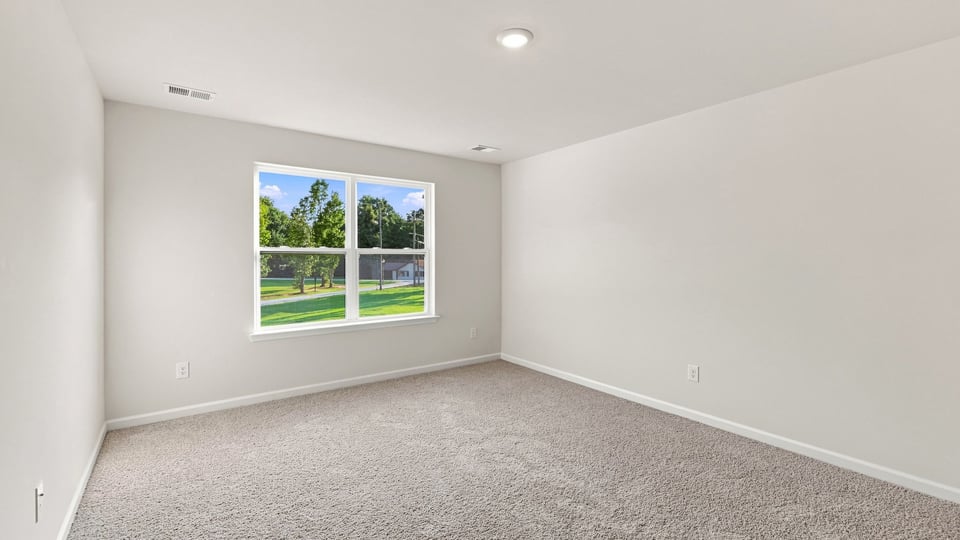 Bedroom with carpet and window.