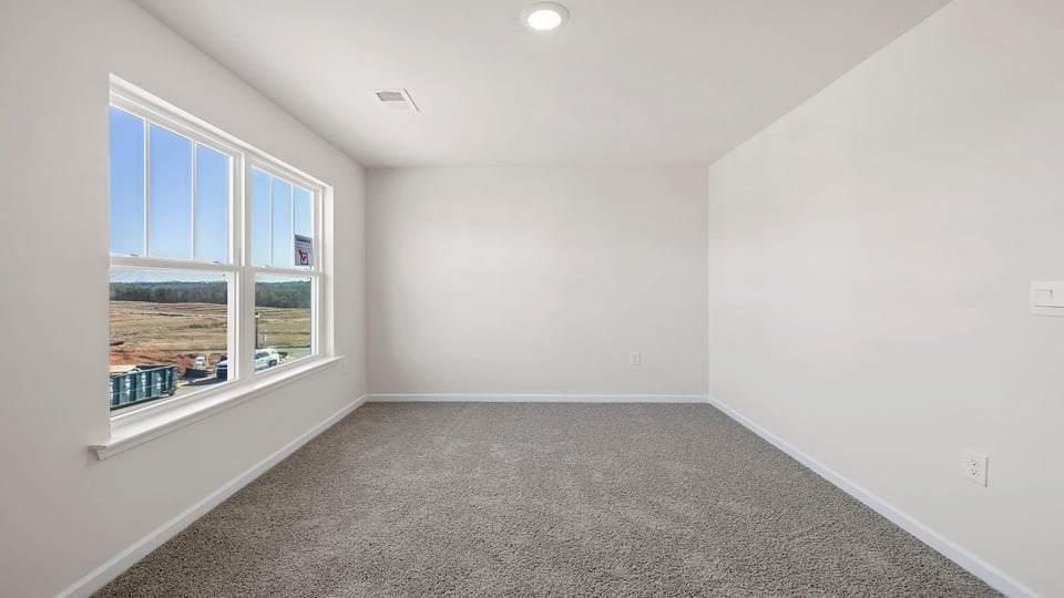 Bedroom with carpet and window.