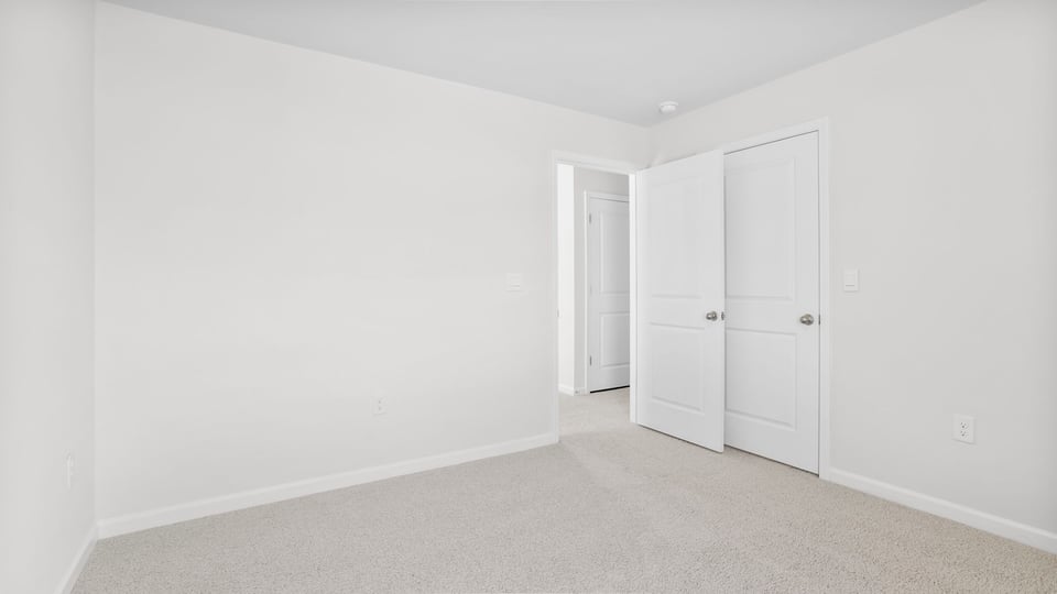 Bedroom with carpet and windows.