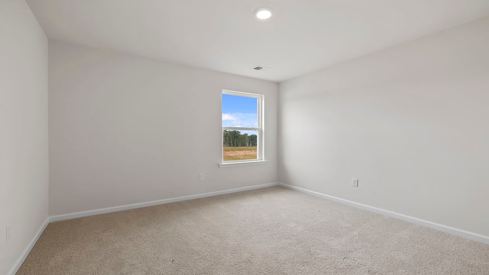 Bedroom with carpet and window.