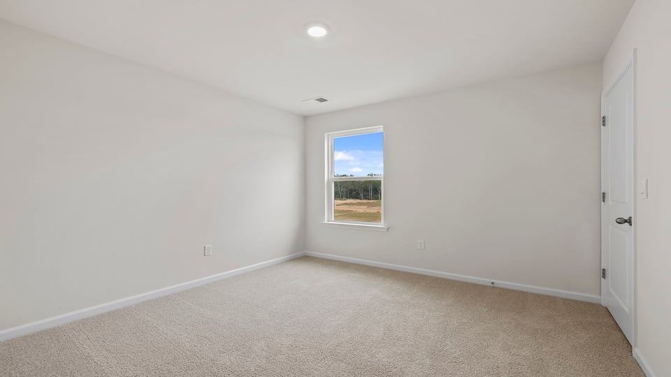 Bedroom with carpet and window.