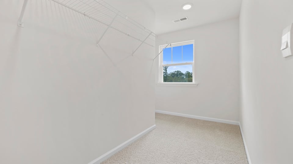 Walk in closet with shelves and window.
