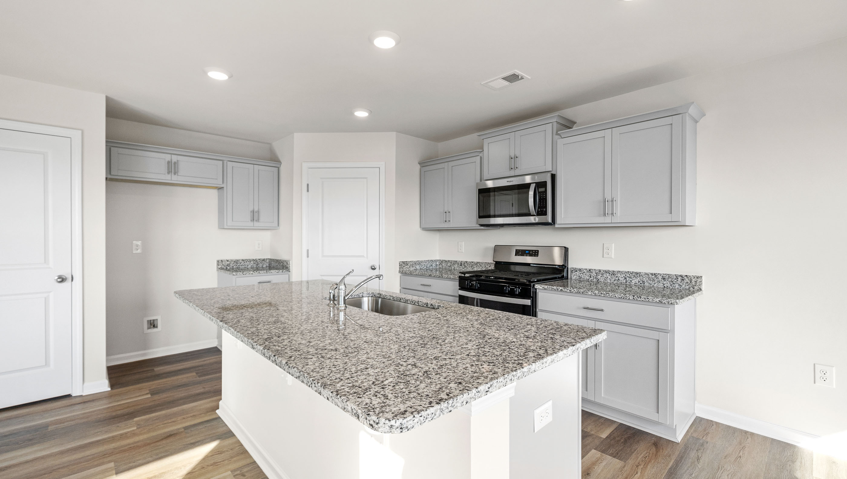 Kitchen with island and granite countertops.