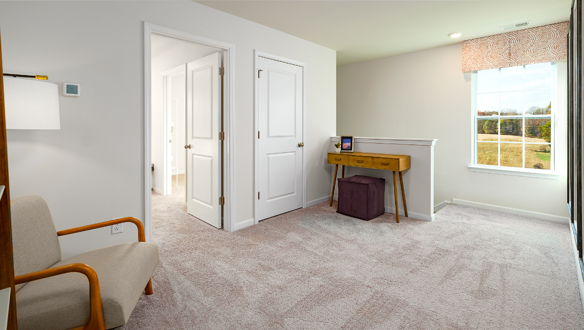 Carpeted loft space with small window