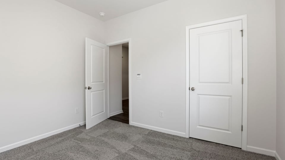 Bedroom with carpet and window.