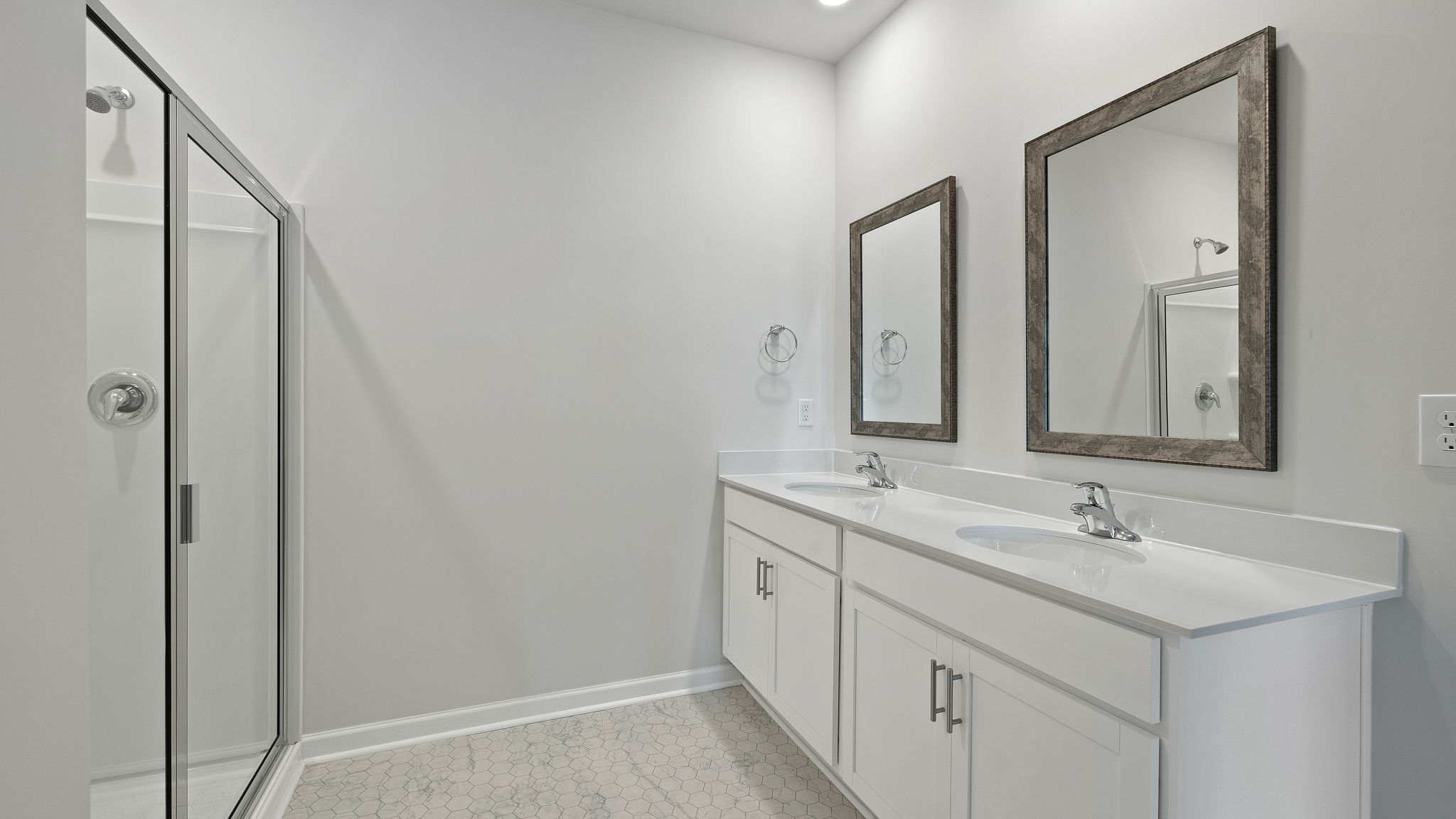 Bathroom with dual vanity and walk in shower.