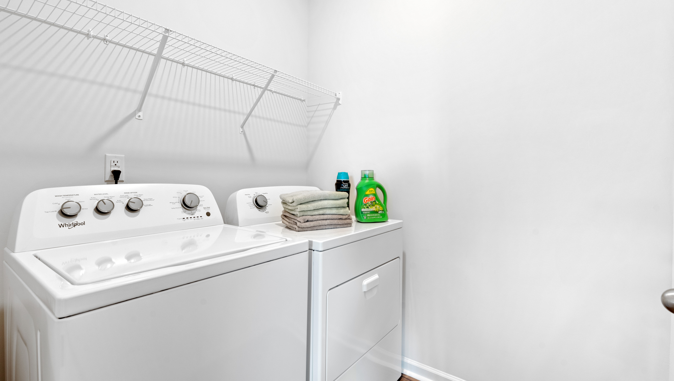 Laundry room with hanging storage racks.