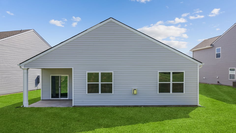 Back exterior of home with large backyard.