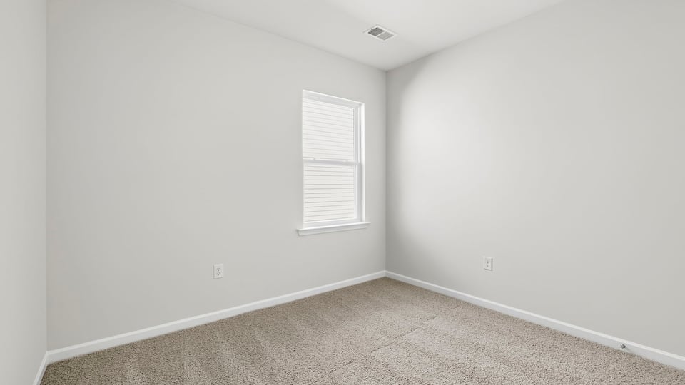 Bedroom with carpet and window.