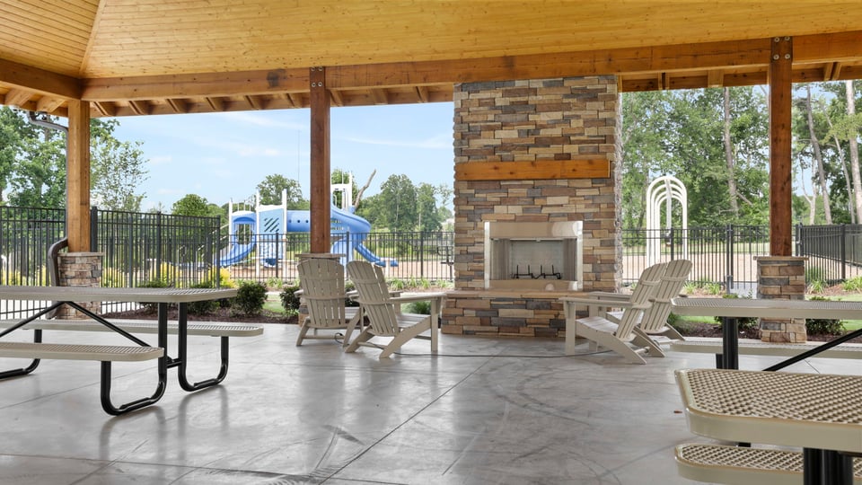 Cabana with fireplace and picnic tables.
