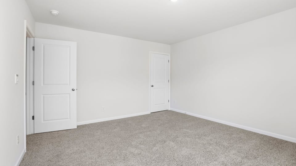 Bedroom with carpet and window.