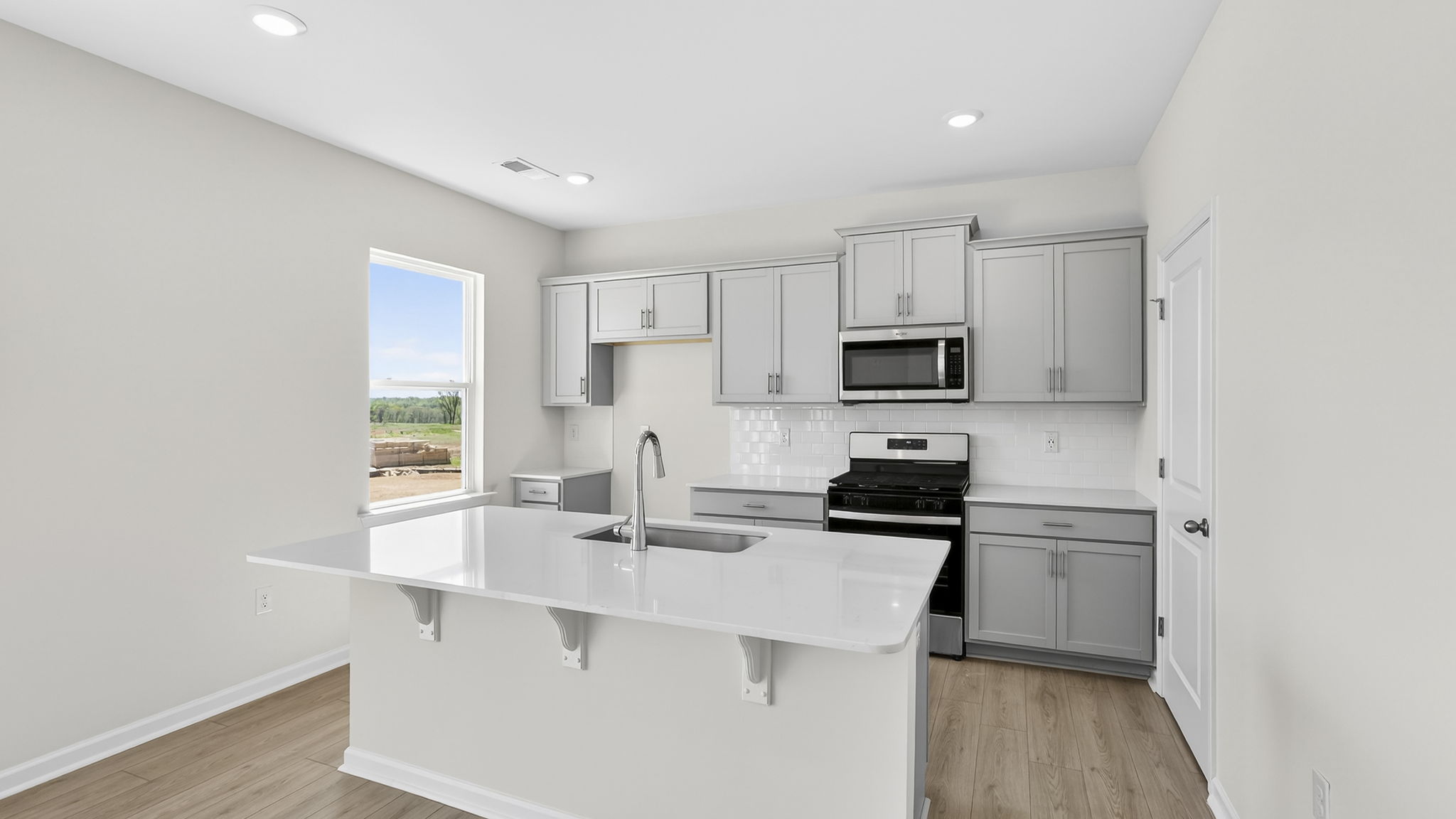 Kitchen with quartz countertops and stainless steel appliances.