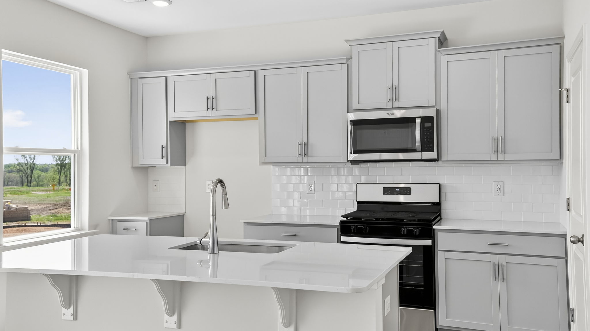 Kitchen with quartz countertops and stainless steel appliances.