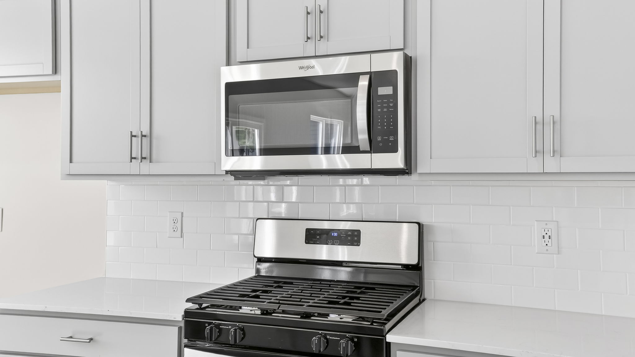 Kitchen with quartz countertops and stainless steel appliances.