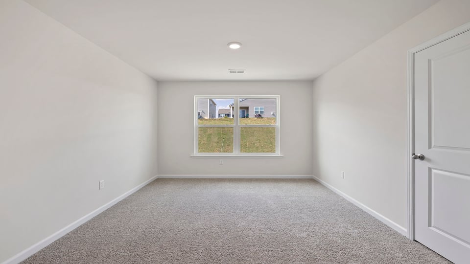 Bedroom with carpet and window.