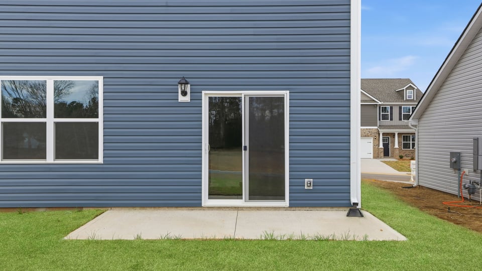 Back exterior of home with patio.