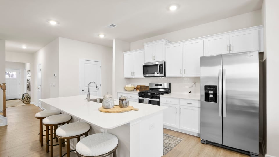 Kitchen and island with quartz and stainless steel appliances.