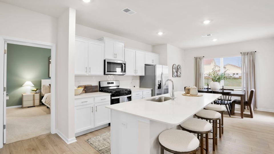 Kitchen and island with quartz and stainless steel appliances.