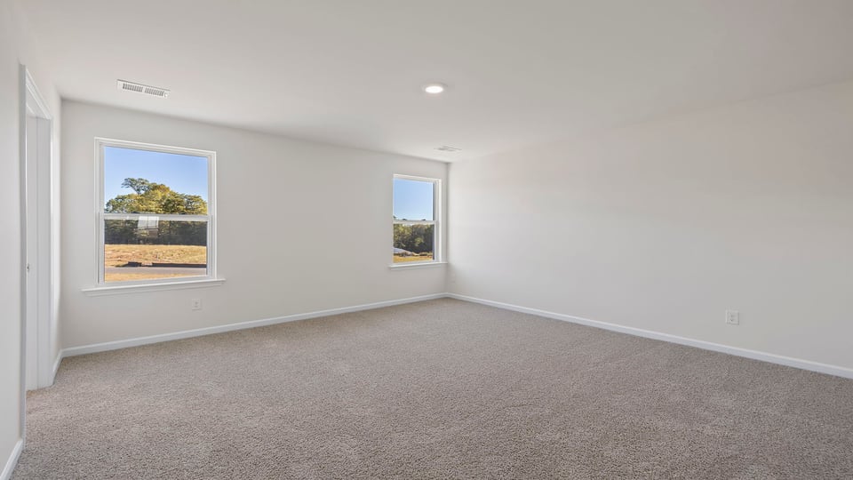 Second primary suite with carpet and windows.