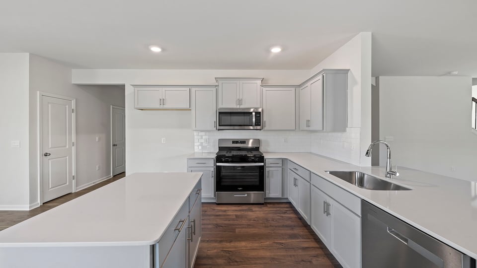 Kitchen with granite countertops with stainless steel appliances.
