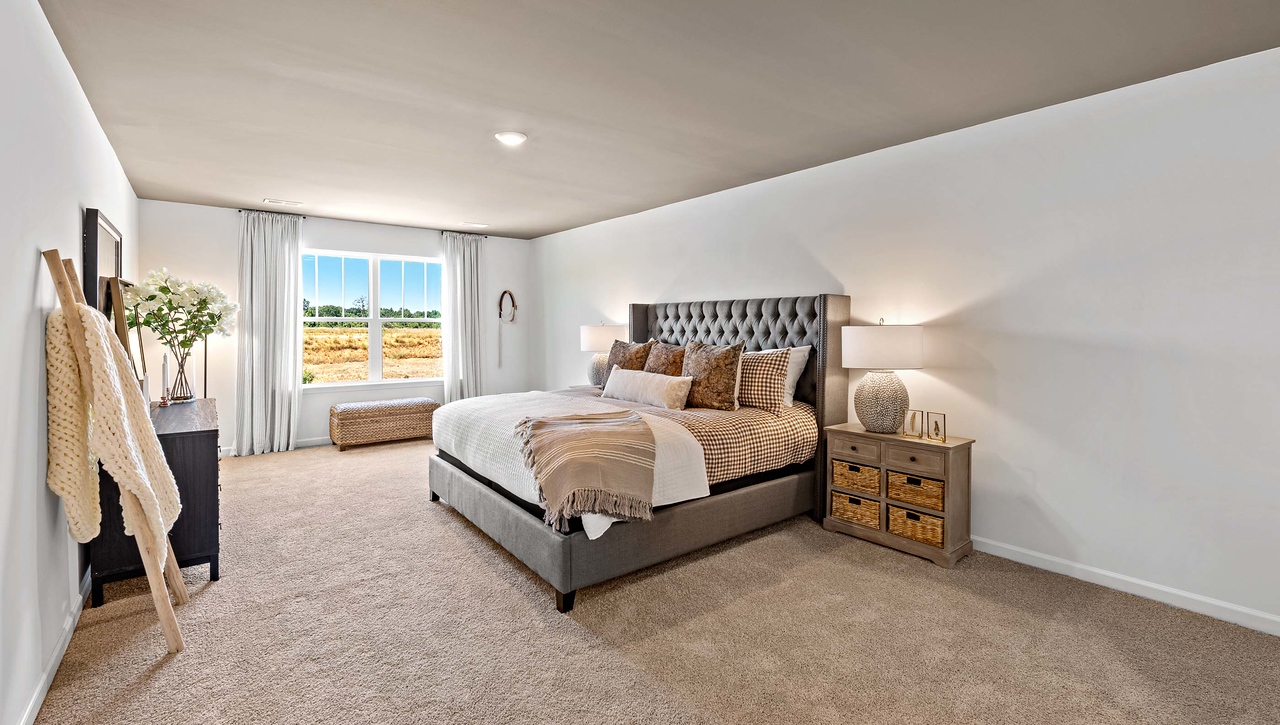 Primary bedroom with carpet and window.