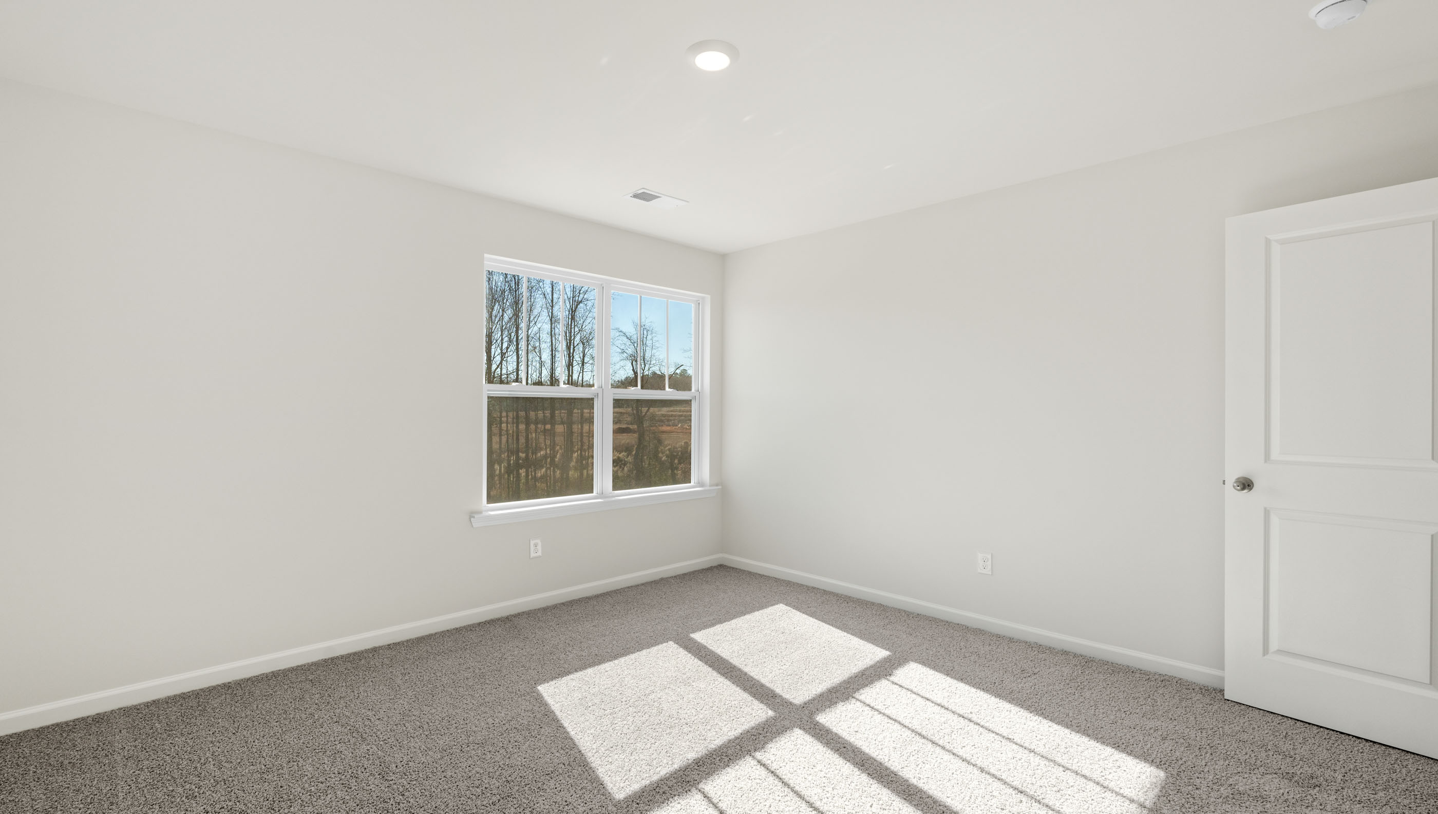 Bedroom with carpet and window.