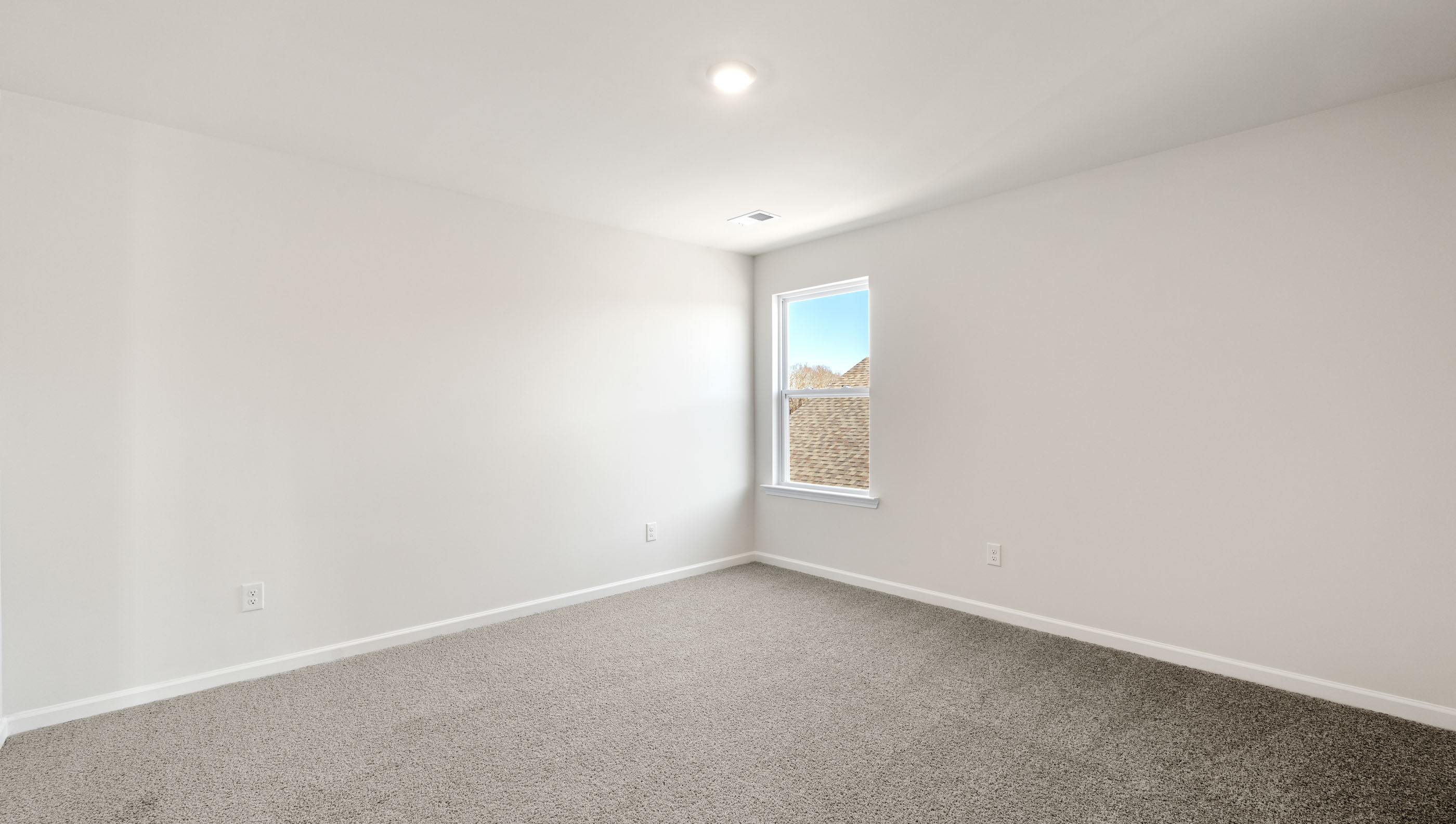 Bedroom with carpet and window.