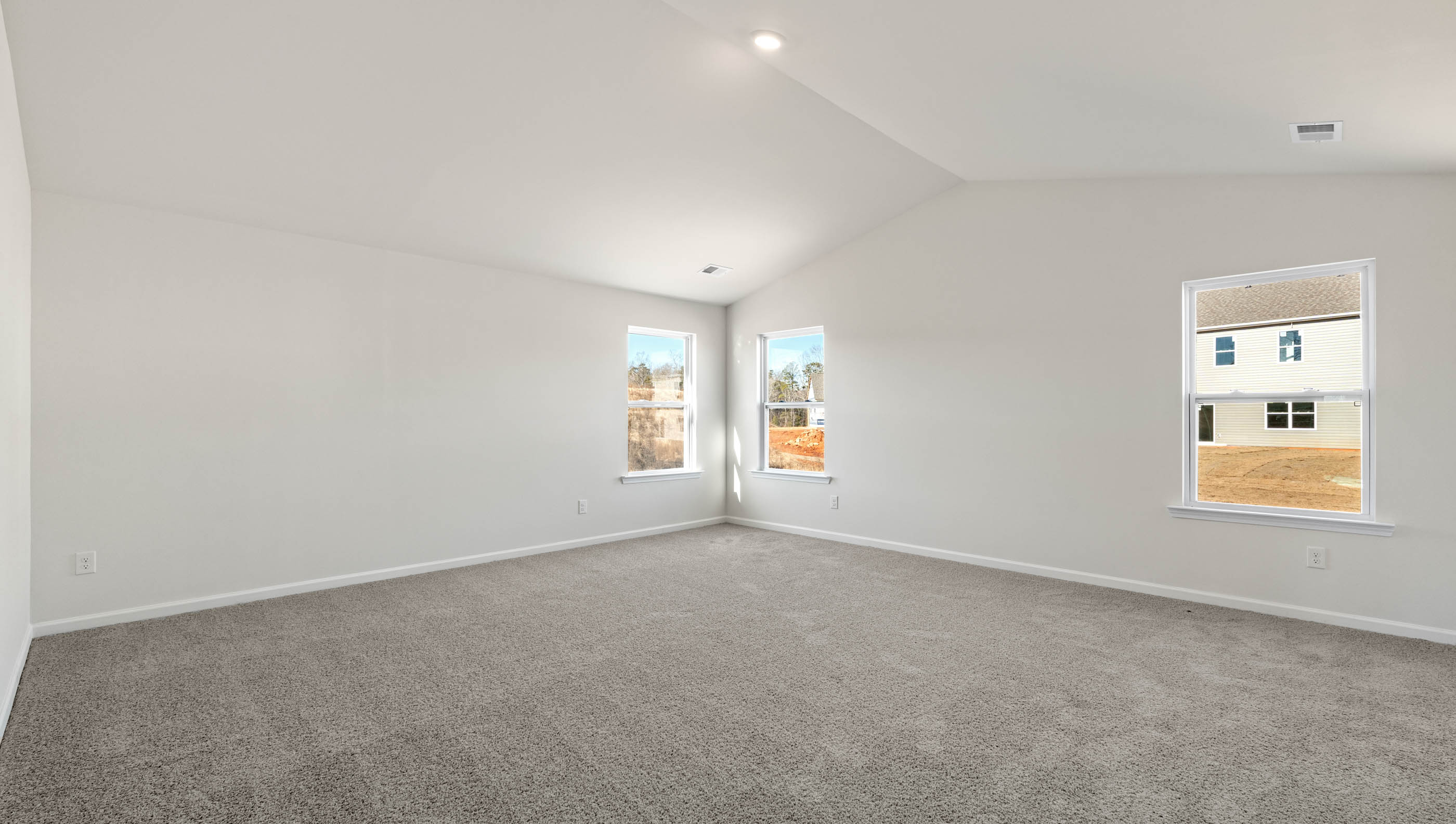 Primary bedroom with carpet and window.