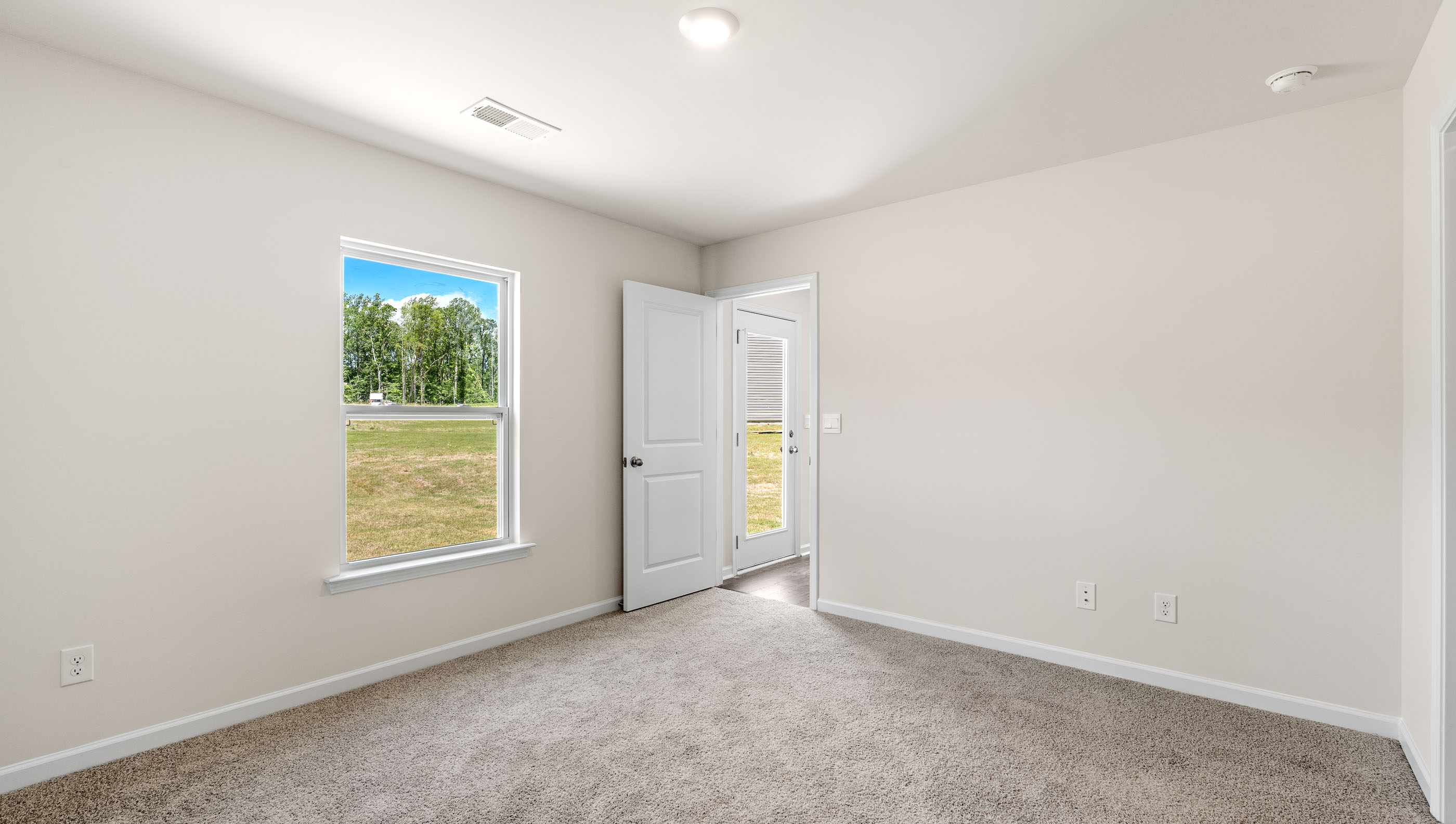 Bedroom with carpet and windows.