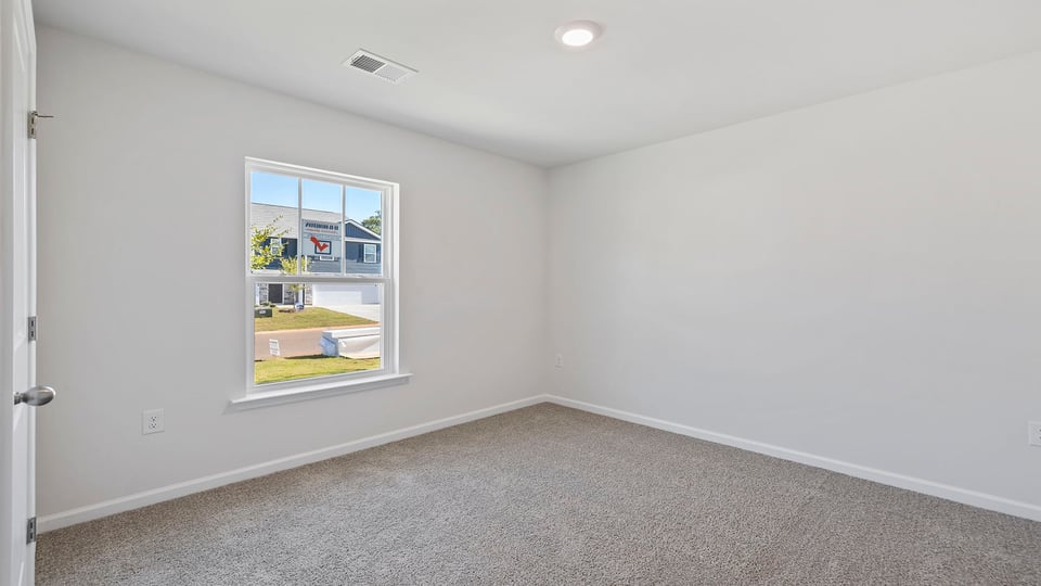 Bedroom with carpet and window.