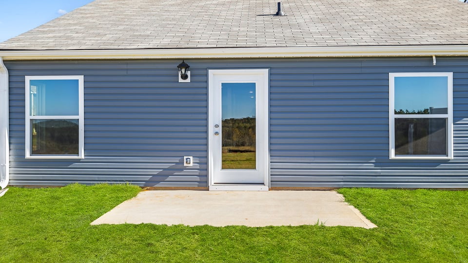 Back exterior of home with patio.