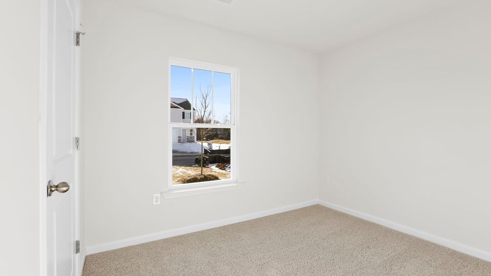 Bedroom with carpet and window.