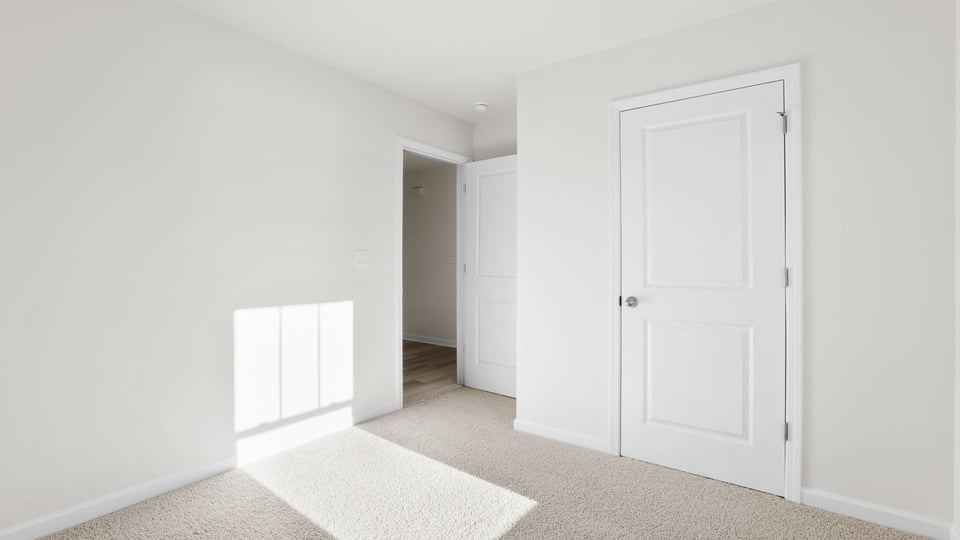 Bedroom with carpet and window.