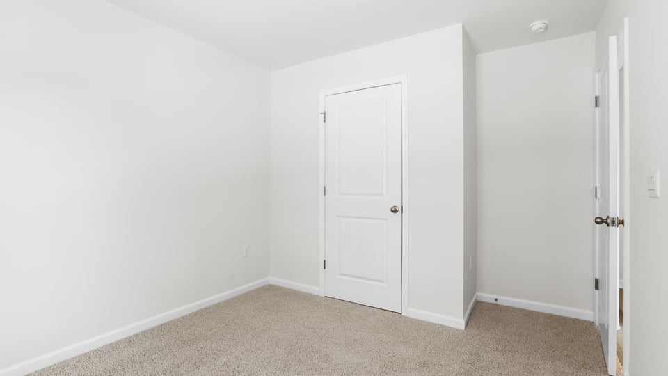 Bedroom with carpet and window.