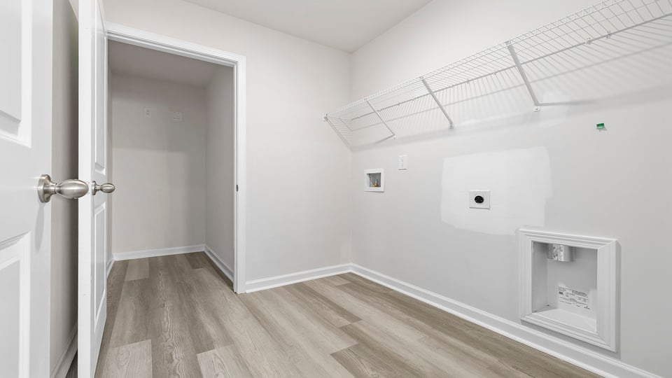 Walk in laundry with hanging shelves.