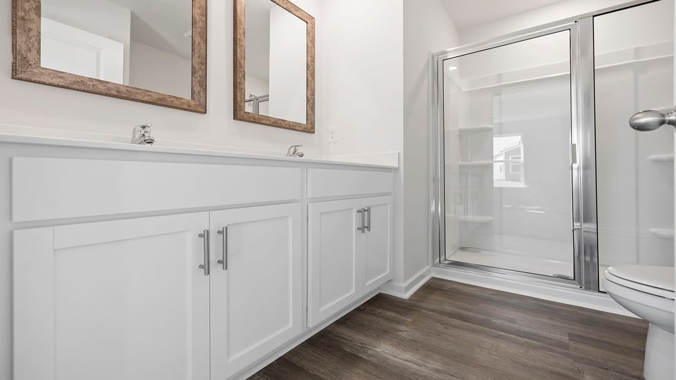 Bathroom with dual vanities and walk in shower.