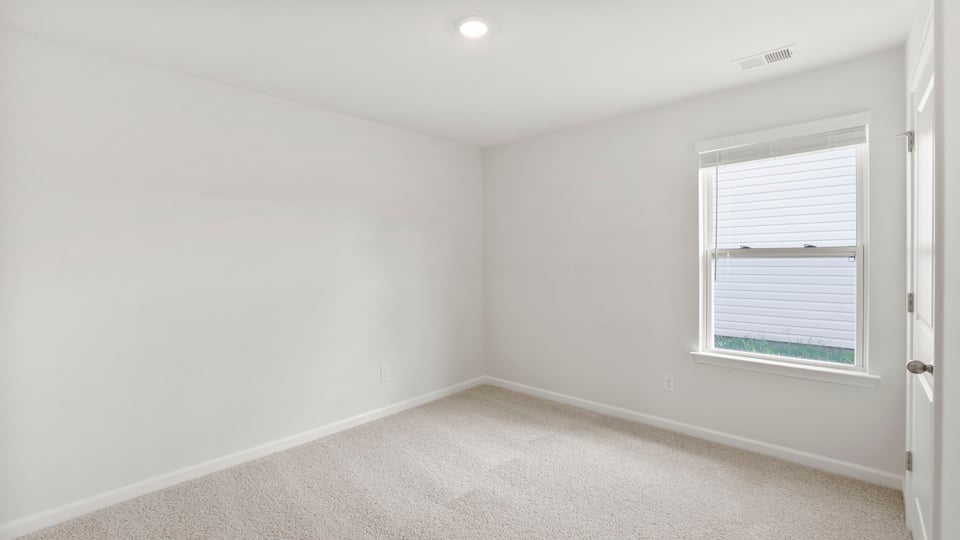 Bedroom with carpet and window.